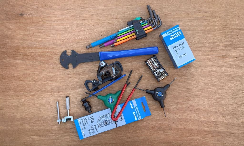 An assortment of bicycle tools laid out on a workbench