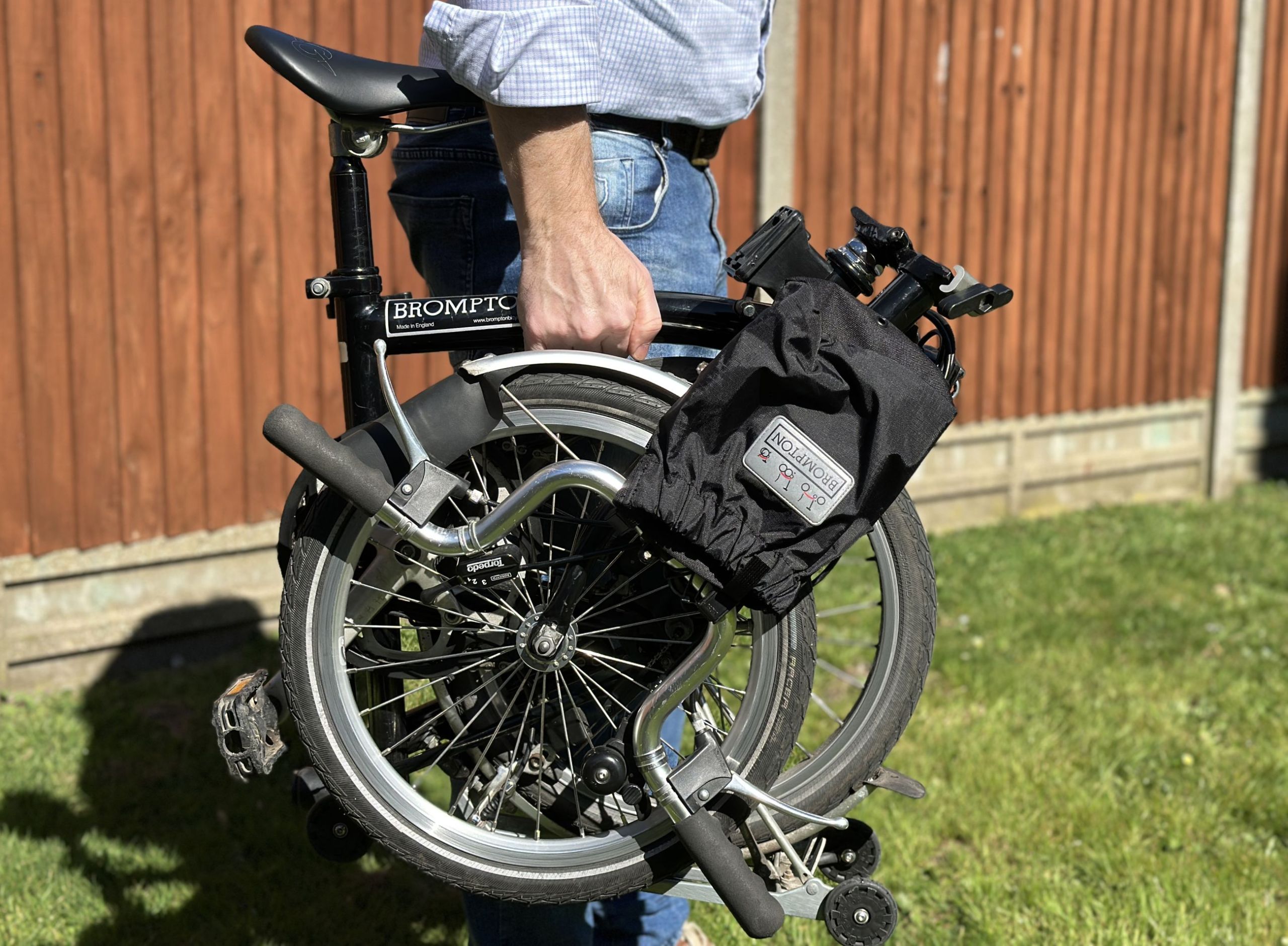 man carrying a folding bike with one hand