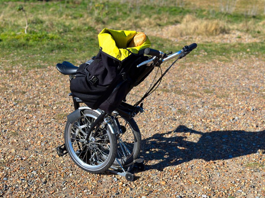 a folded bike converted to a shopping cart on a gravel path